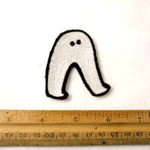 A photo of a small iron-on patch of a simplistic Fresno Nightcrawler. It's about 2.5 inches tall